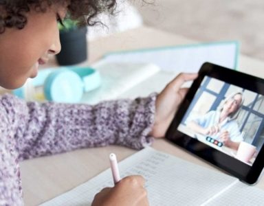 Child holding a tablet for virtual one-on-one tutoring session
