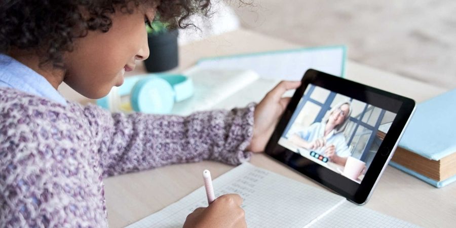 Child holding a tablet for virtual one-on-one tutoring session