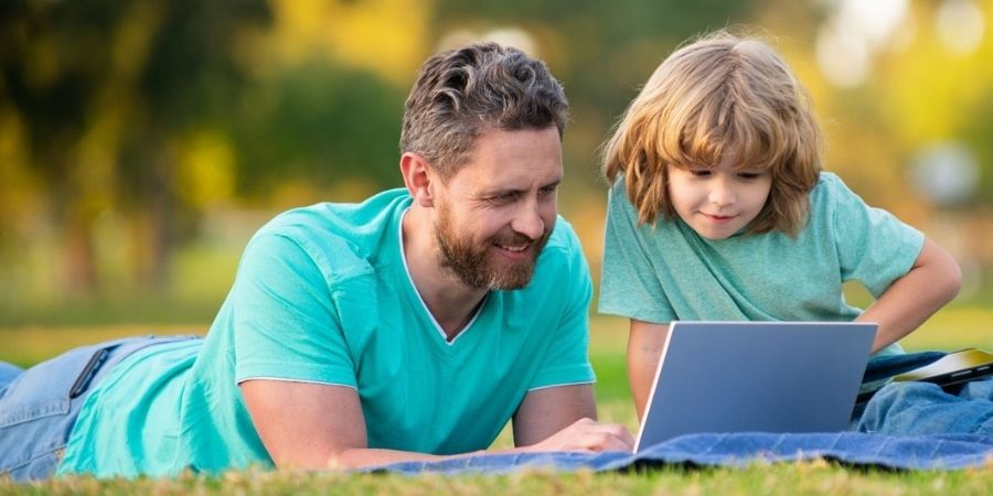 Father and son learning together in summertime