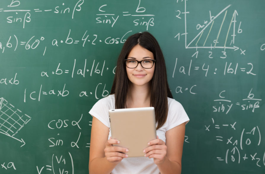 Happy teen student in front of a maths chalk board