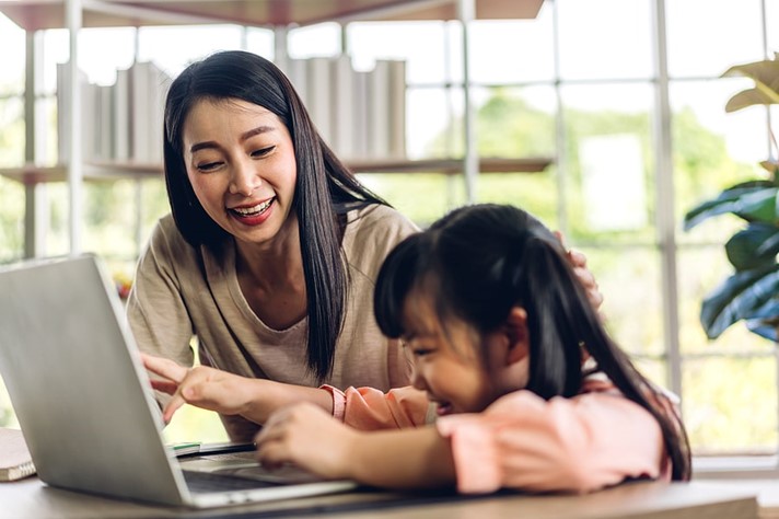 Mother and child setting learning together on a laptop